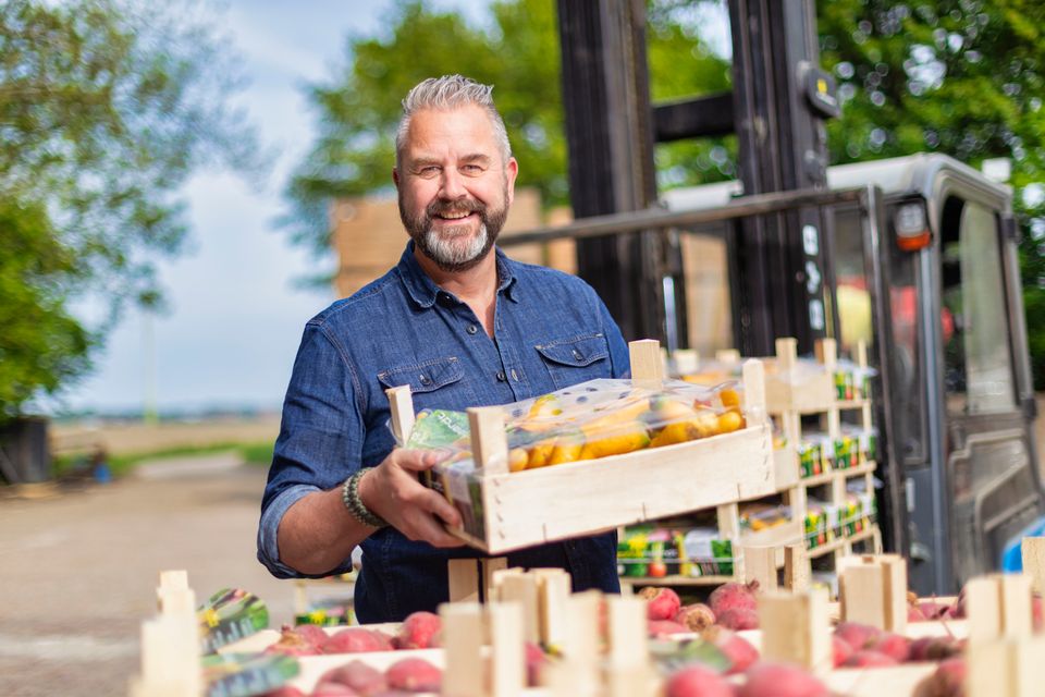 Een man laadt fruitkistjes uit in Flevoland