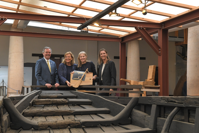 Vier personen bij een van de gerestaureerde Zwammerdamschepen.