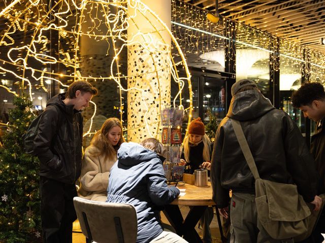 Bezoekers die een kaartje schrijven tijdens Lichtjesavond op het NS station