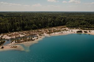 Het blauwe water, het strand en het bos bij het Gasselterveld op een zomerse dag vanuit de lucht.