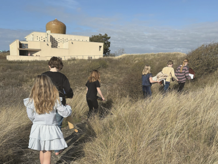 Kinderen in het duingras onderweg naar de tempel