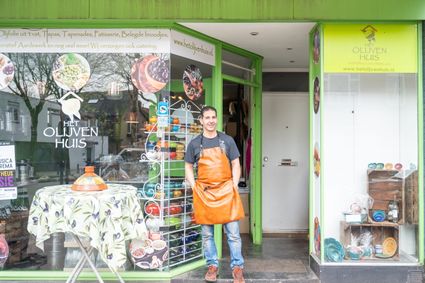 Het Olijvenhuis met eigenaar voor de winkel
