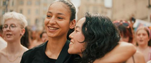 twee personen lachen en slaan hun armen om elkaar heen