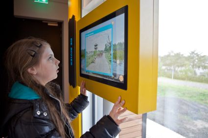 Kind kijkt door een kijkvenster in Museum Hoge Woerd