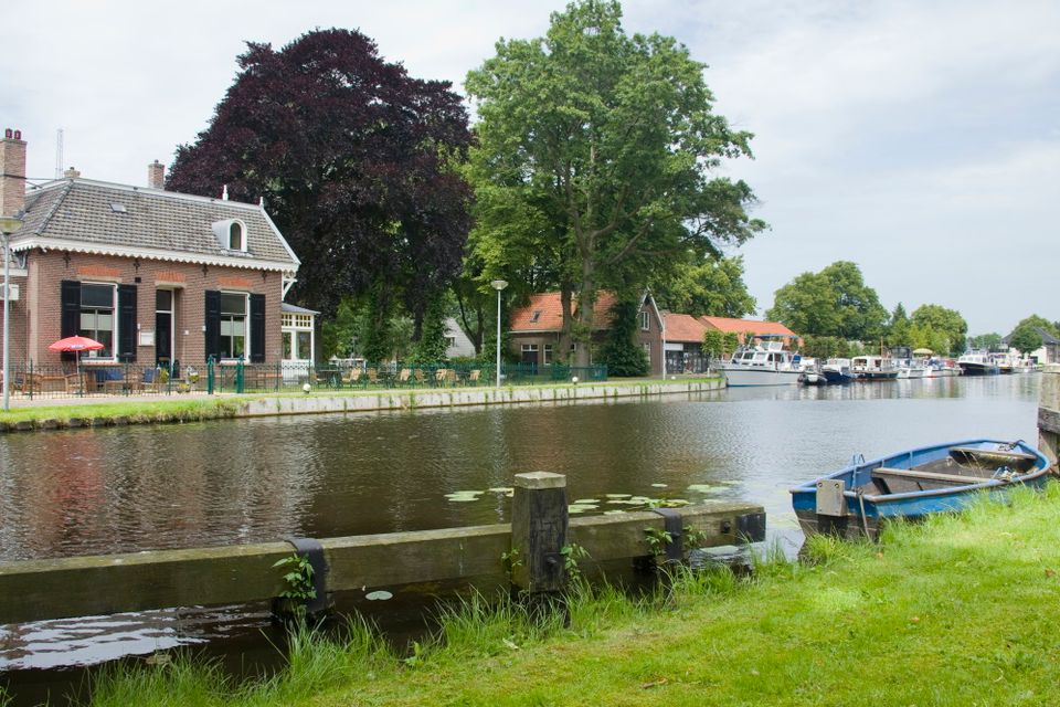 Een kanaal met boten en een restaurantje op de achtergrond.