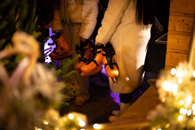 Persoon met schaatsen in de hand