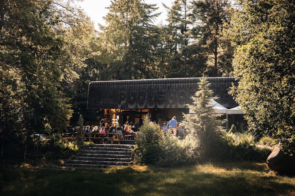 Eine Terrasse mit Menschen an einem Waldcafé in Drenthe, Niederlande.
