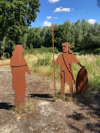 Twee stalen Romeinen naast een watertje.