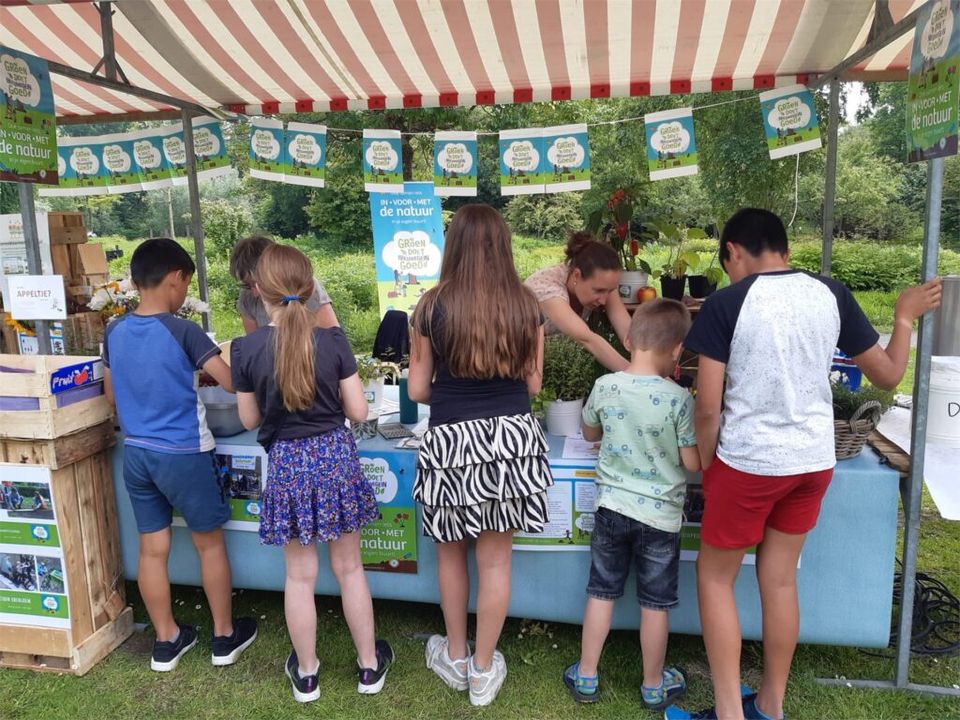 Kinderen bezoeken een kraampje van het natuurkwartier