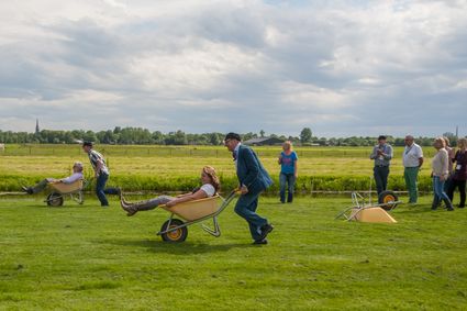Boerderij De Boerinn in Kamerik, Groene Hart, boerenspellen met kruiwagenrace als groepsactiviteit en teamuitje in het weiland met deelnemers en toeschouwers.
