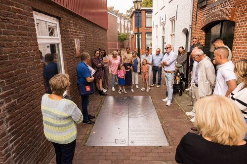Een groep mensen luistert naar een gids die vertelt over de stad.
