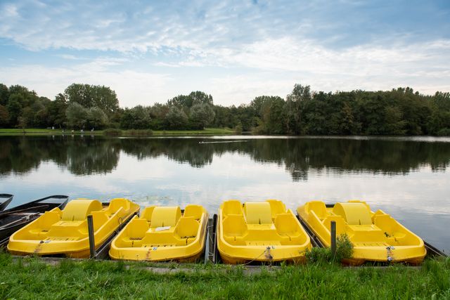 Vier gele fietsbootjes op een rij in het water in het Westerpark in Zoetermeer.