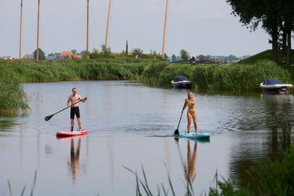Twee mensen SUPpen door Sloten.