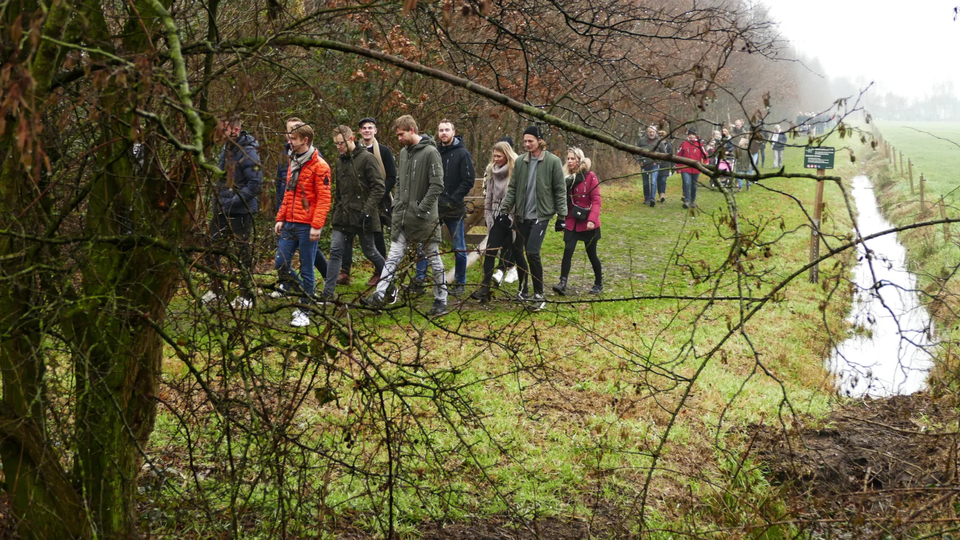 Mensen wandelen de Krystkuier door het bos van Sint Nicolaasga.