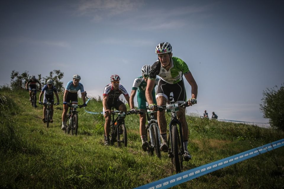 Mountainbikers fietsen achter elkaar van een heuvel tijdens een wedstrijd.