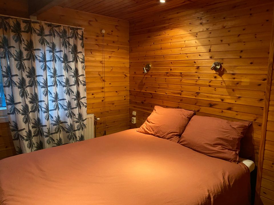 De 2 persoonsslaapkamer heeft een Swiss Sensbed van 160 breed en is heerlijk knus met het hout. Er hangen verduisterende gordijnen zodat je goed kunt uitslapen, ook in de zomer. En een hor tegen de muggen