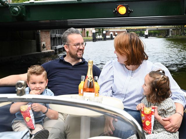 Een gezinnetje met jonge kinderen op een bootje van Randstad Recreaties in Delft