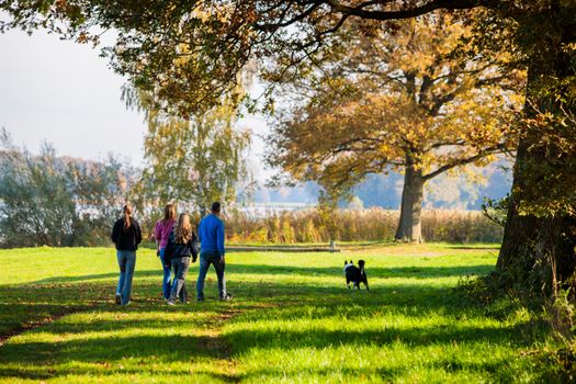 Gezin met hond aan het wandelen.
