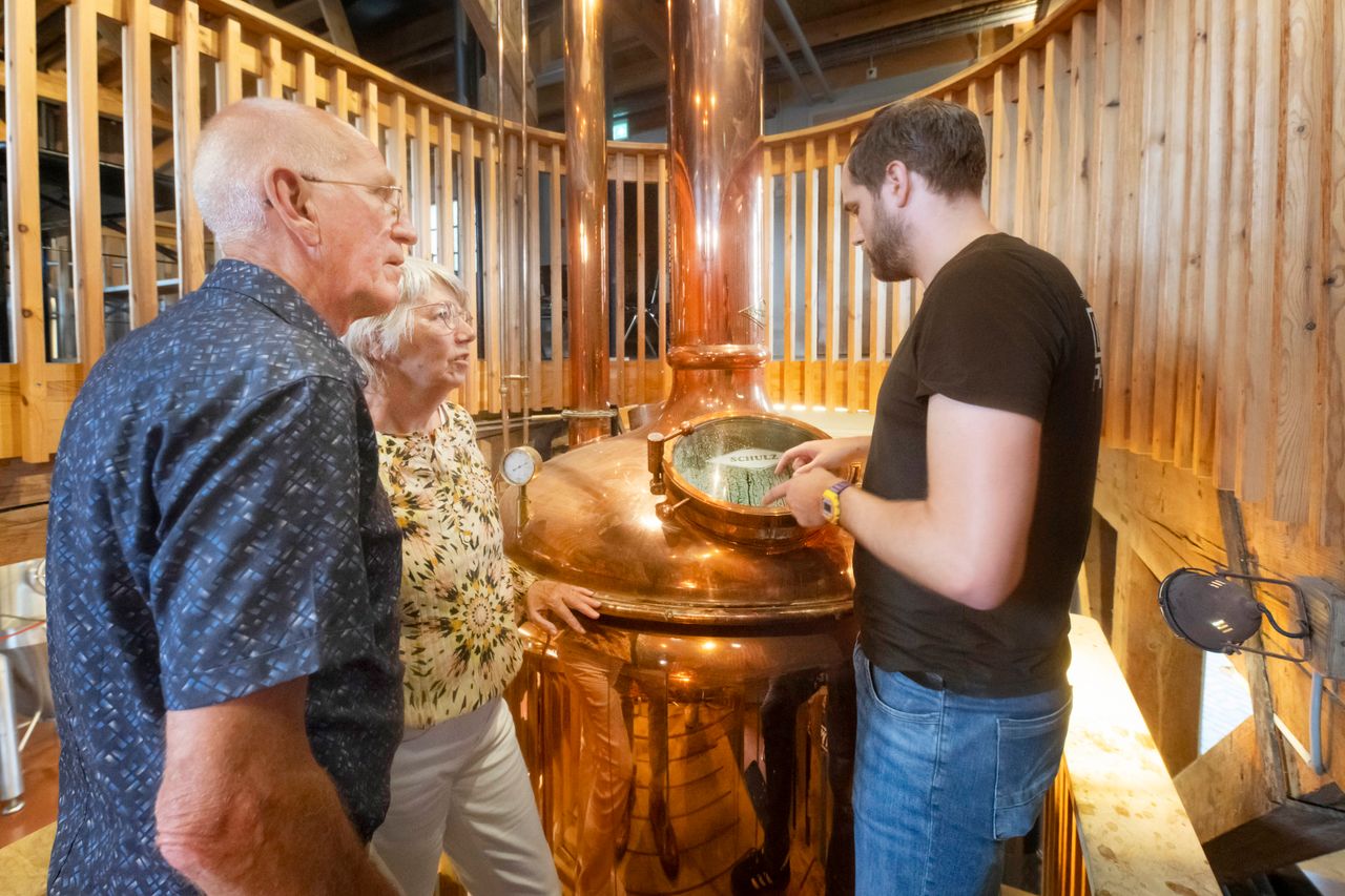 Echtpaar dat een excursie krijgt bij de koperen ketels van bierbrouwerij Maallust