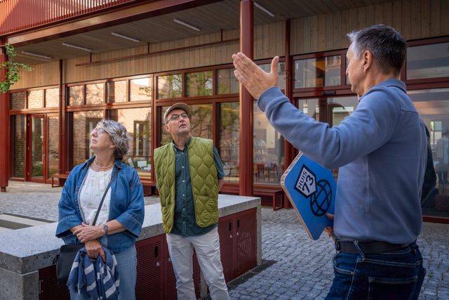 Gids geeft een rondleiding door het vernieuwde Huis73 aan bezoekers