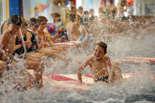 Kinderen spetterend in zwembad.