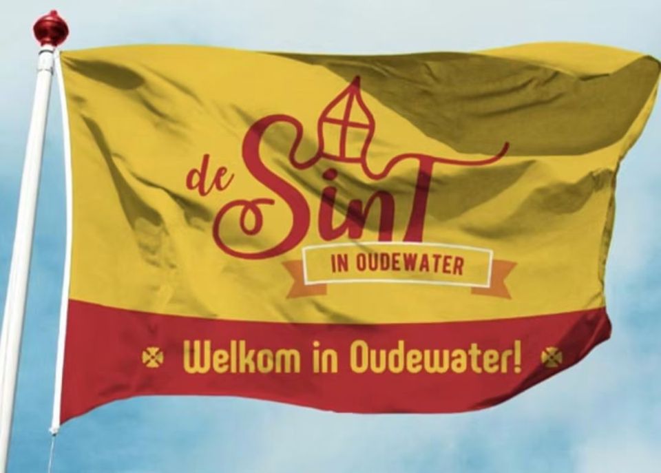 Gele vlag met rode details, de vlag van Sinterklaas aan een mast met blauw lucht op de achtergrond in Oudewater