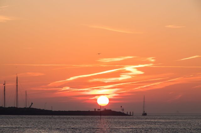Silhouet van de jachthaven Vlieland bij opkomende zon