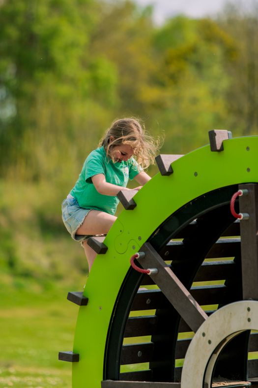 Meisje klimt op een klimrek.