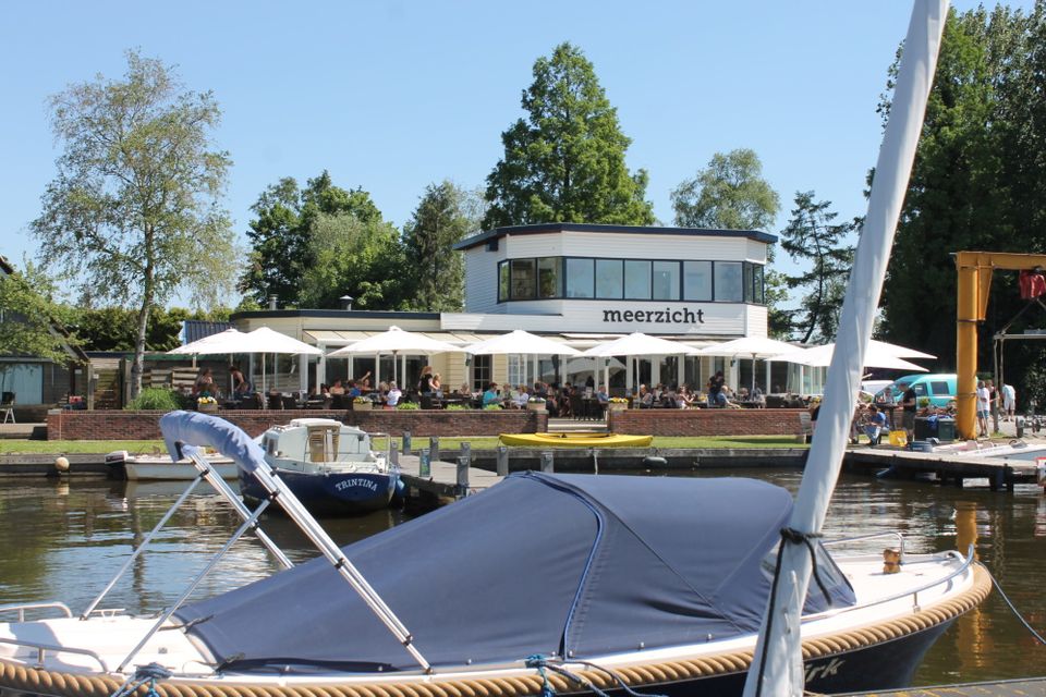 Haven met bootjes, op de achtergrond het terras van Paviljoen Meerzicht.