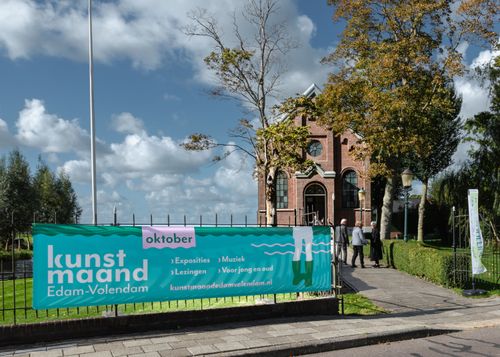 Een foto van het kerkje in Middelie met een spanddoek van de Kunstmaand