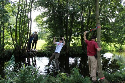Groepsactiviteit Expeditie Kameryck bij Buitenplaats Kameryck in Kamerik, deelnemers steken via een touwparcours het water over tijdens een actief teamuitje in het Groene Hart