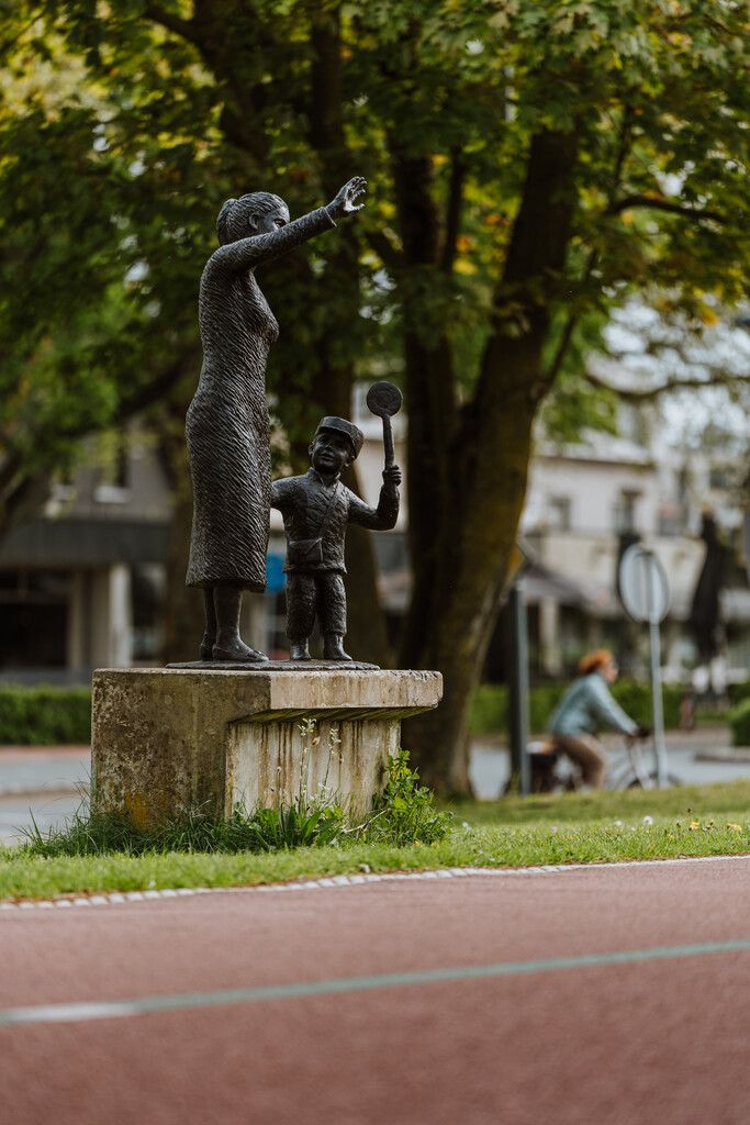 Standbeeld van een moeder en kind die zwaaien.