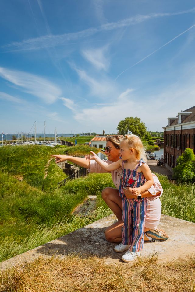 Een moeder met dochter kijkt naar het uitzicht vanaf een bastion.