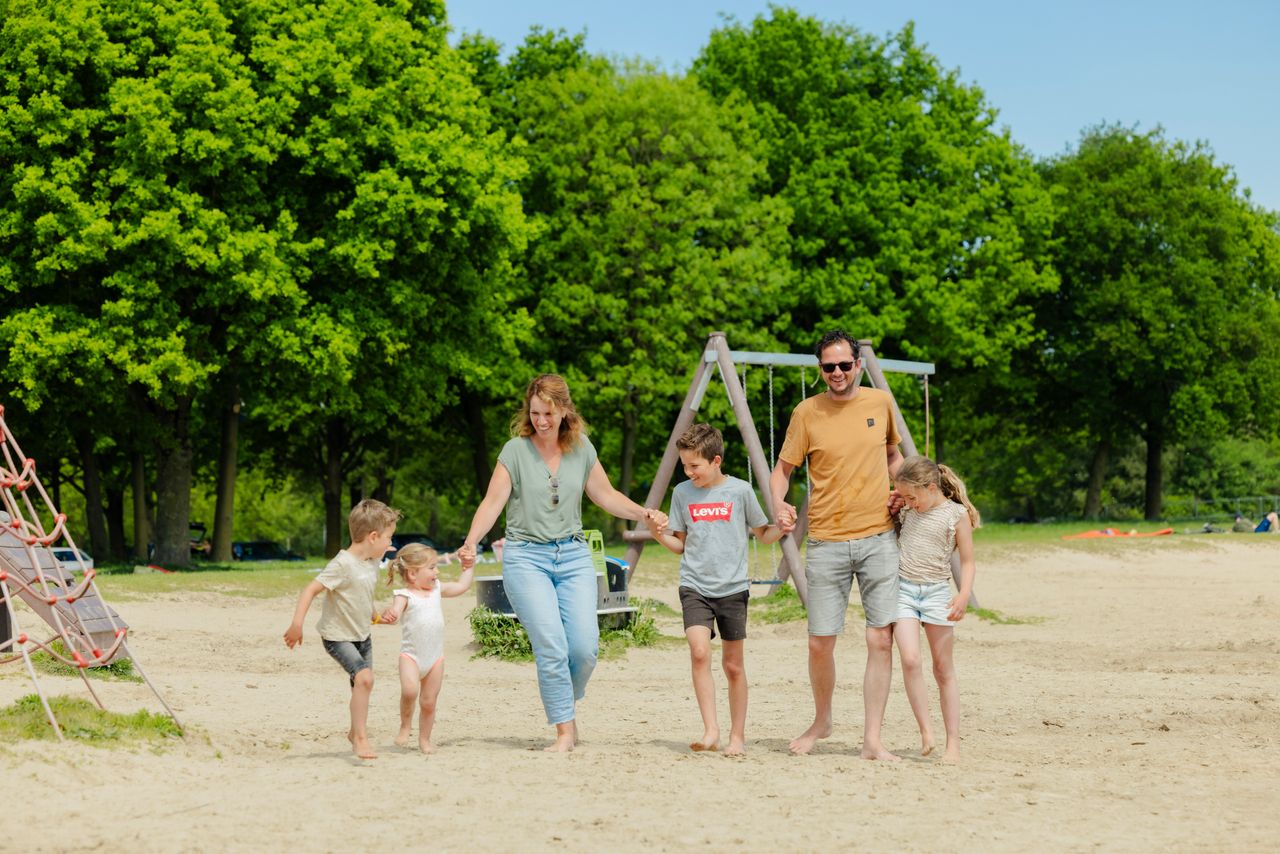 Gezin loopt op het strand