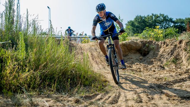een mountain biker fietst door het zand