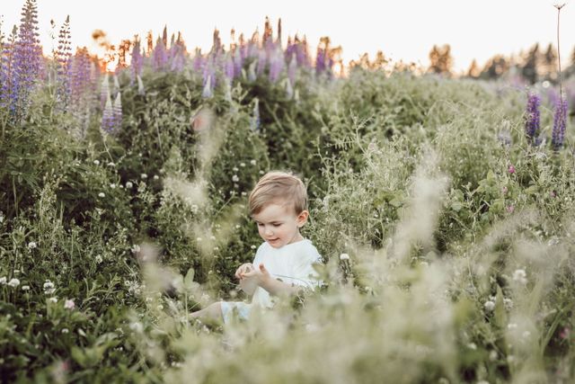 Een kind zit midden tussen de bloemen