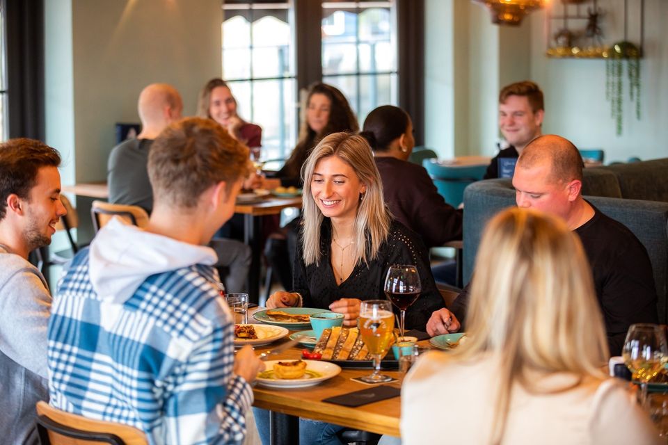 Mensen die gezellig aan het eten en drinken zijn bij Restaurant Pieterman in Volendam