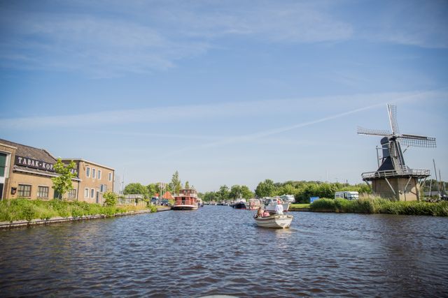 Sloep vaart langs de oude DE fabriek