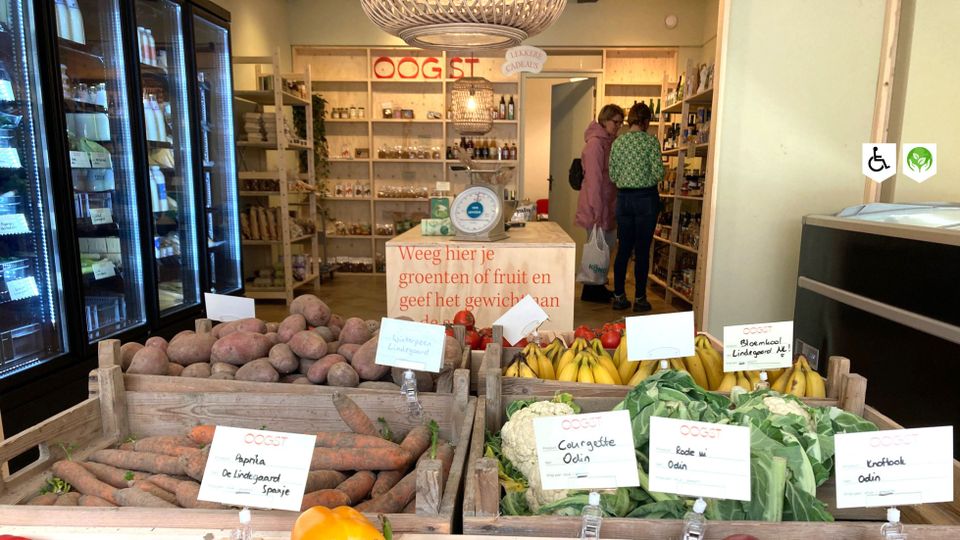 Winkel Oogst Shop Woerden, provincie Utrecht, Groene Hart, houten kisten met aardappelen, wortels, bananen en bloemkool in een duurzame streekwinkel waar klanten lokale producten uitzoeken.