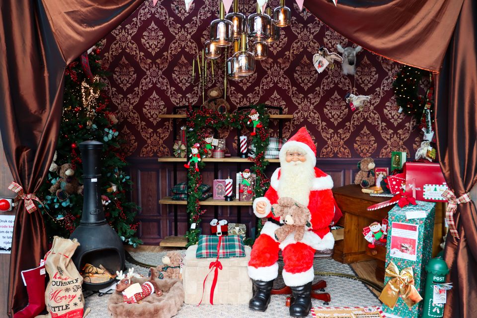 Kerstshow bij Tuincentrum De Bosrand in Woerden, provincie Utrecht, met een zittende kerstman, knuffelberen, kerstcadeaus, versierde kerstbomen en sfeervolle kerstdecoratie.