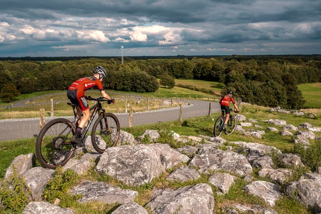 Twee mensen op een mountainbike rijden over rockgardens (pad van stenen) naar beneden de VAM-berg af.