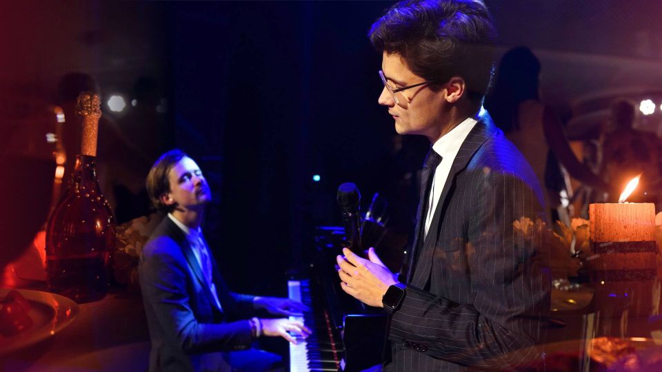 Een man die aan het zingen is en een man die de piano bespeelt