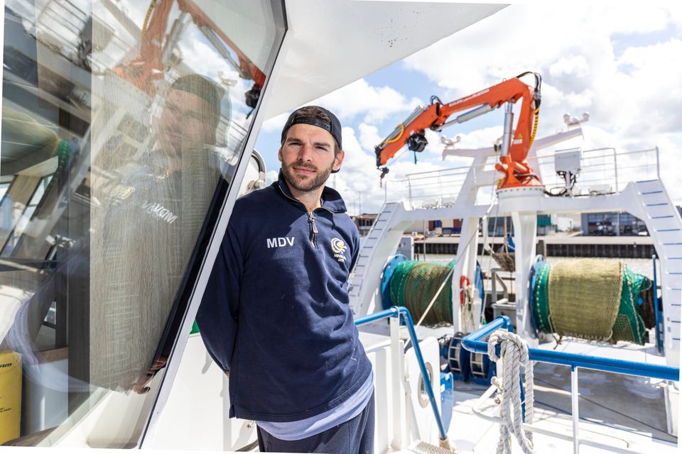 Een visser op een schip in de haven van Flevoland