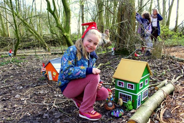 Een meisje bij een poppen huis waar kabouterbeeldjes staan in het Kabouter bos.