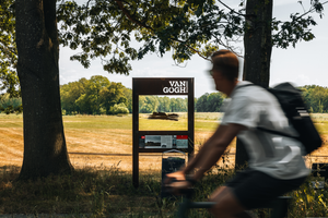 Een man fietst door het Drentse landschap langs een doorkijkpaneel met een schets van Van Gogh.