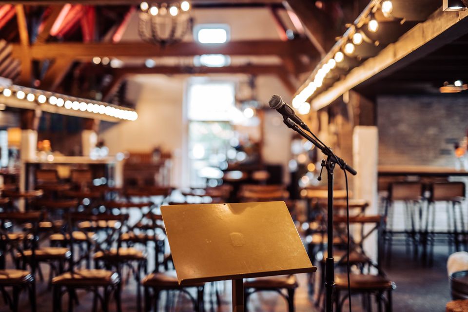 Evenementenlocatie De Willemshoeve in Woerden, Groene Hart. Vergader- en evenementenruimte met microfoon, spreekgestoelte en sfeervolle verlichting voor zakelijke bijeenkomst, presentatie of congres in historische boerderij.