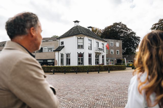 Een man en een vrouw staan vóór het Van Gogh Huis in Nieuw Amsterdam waar Van Gogh enkele maanden verbleef.