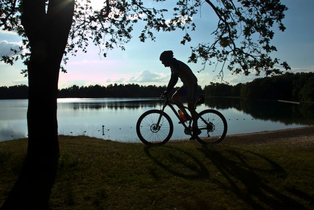 Een mountainbiker fietst langs een zwemplas.