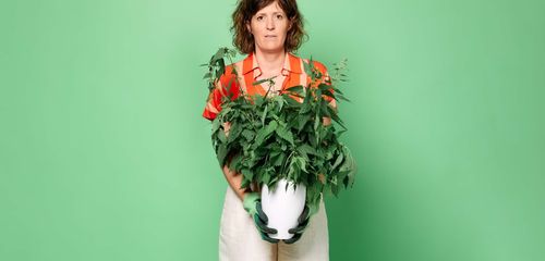 Een vrouw met een brandnetel plant in haar handen