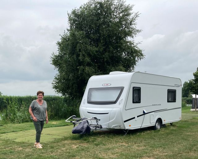 Vrouw naast caravan